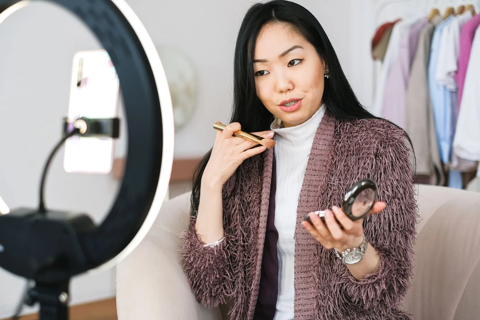 Cô gái thử cọ và phấn trang điểm trước đèn vòng
