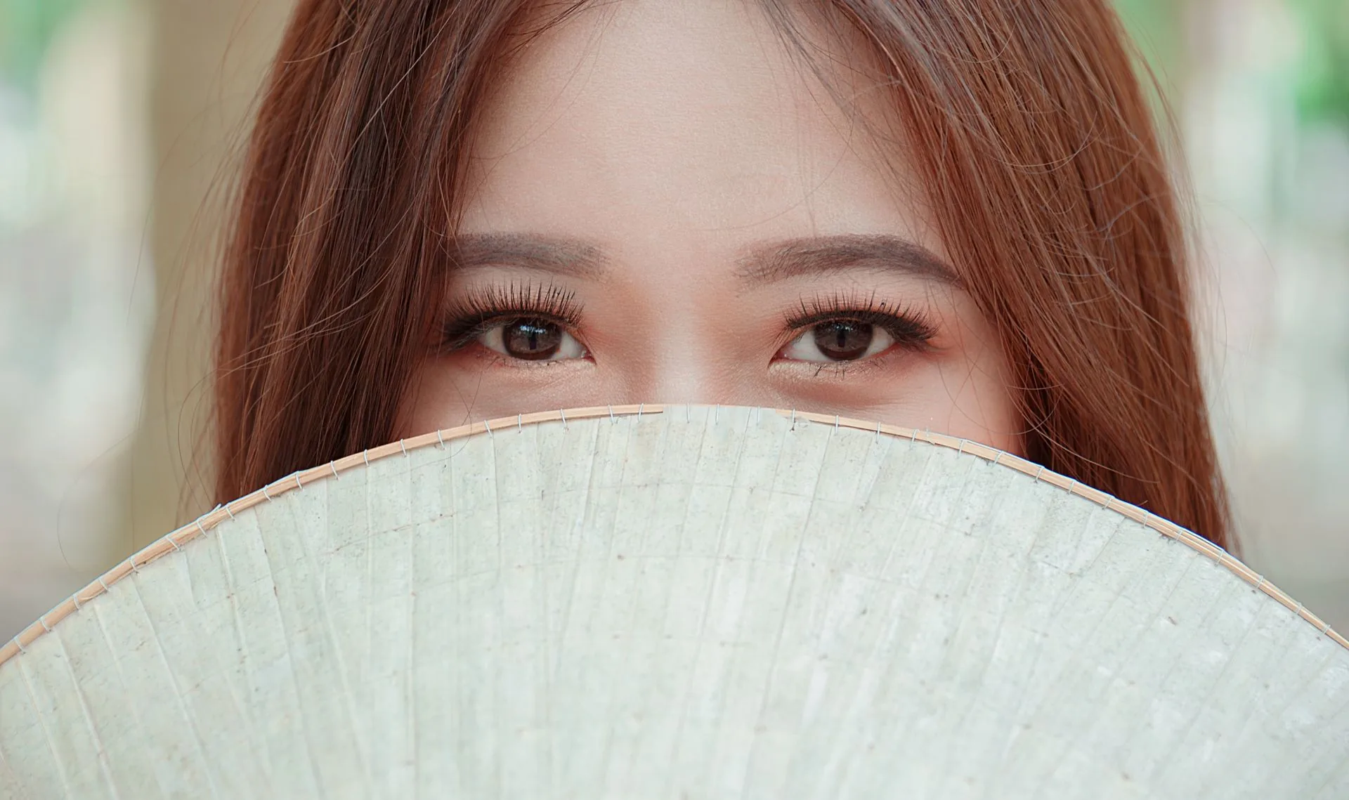 Đôi mắt trang điểm nhẹ phía sau chiếc nón lá